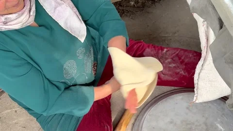 Skillful bakery bake flat bread using flour dough and hit on a tube wood Stock Footage 245411137