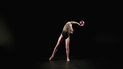 Skillful charming gymnast making figure eight elements with ball Stock Footage 309743559