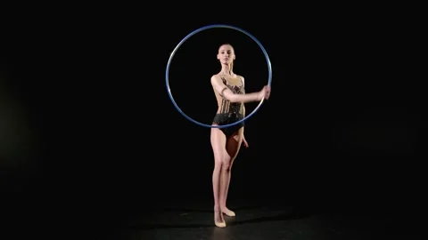 Skillful fit charming rhythmic gymnast rotating bright hoop around hands Stock Footage 309743644