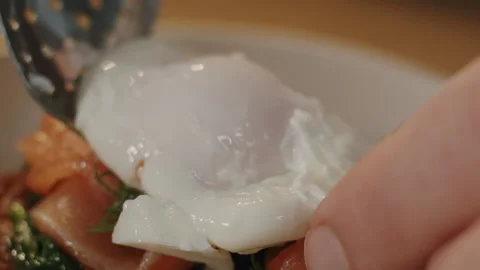 Skillful hands of the cook with a spoon put a tender poached egg on crispy toast 스톡 동영상 150963709