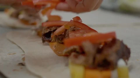 Skillful hands prepare kebab with fresh toppings on soft lavash bread Stock Footage 329268901