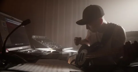 Skillful man composing on bass guitar in sound studio Stock Footage 249913637