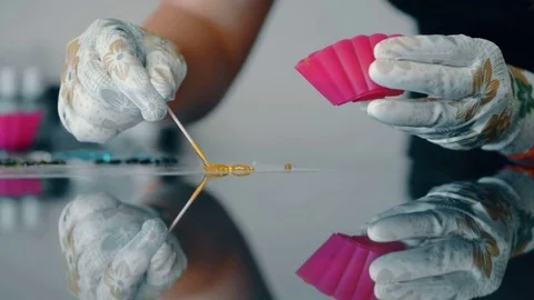 Skillful master makes figure from sticky caramel on glass table indoors. Stock Footage 81159007