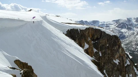 Skillful paraskier speed flying near the snowy mountain slope Stock Footage 116743503