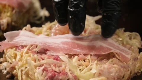 Skillful Preparation of Traditional Hiroshima-Style Okonomiyaki on Teppan Grill Stock Footage 333489850