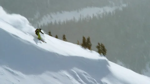 Skillful skier jumping and skiing on the slope of snow-covered mountain Stock Footage 116786169