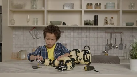 Skillful smart cute black boy checking function of broken toy after repair Video stock 260383081
