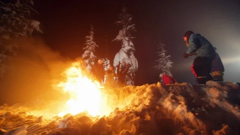 Skillful snowboarder jumping over fire at night Stock Footage 116783234