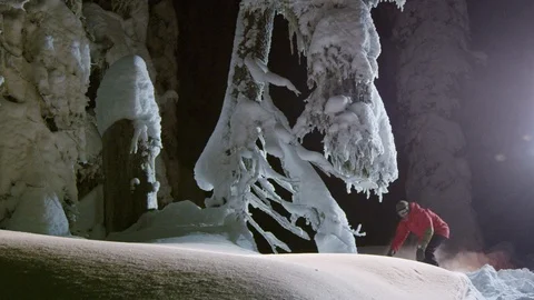 Skillful snowboarder rolling through deep powder snow at night Stock Footage 116783313