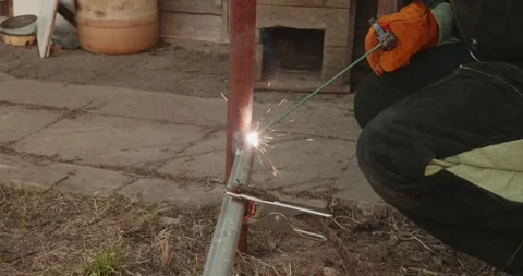 Skillful welder wearing protective gloves using an arc welding machine to join Stock Footage 334335290