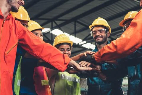 Skillful worker stand together showing teamwork in the factory . Stock Photos