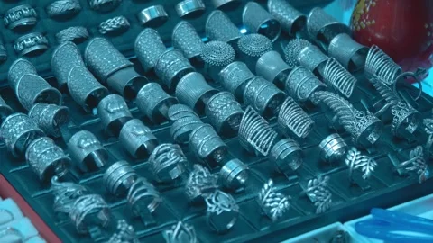 Skillfully crafted silver rings are lying on the display case of a jewelry shop Stock Footage 318683205