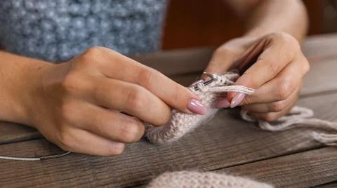 Skillfully knitting a piece using light-colored yarn, perhaps creating a so.. Stock Photos