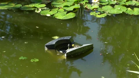 Skimmer Messner swims on surface of water in pond and collects leaves and dirt. Stock Footage 134042625