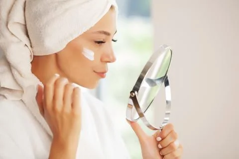 Skin care, beautiful model applying cosmetic cream treatment on her face Fotos Stock