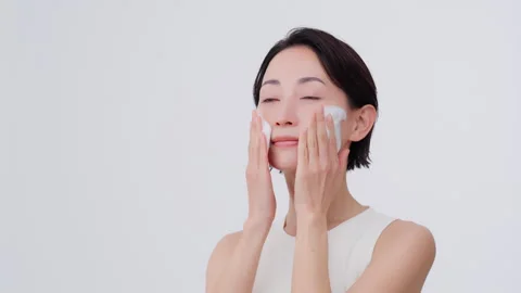 Skin care process. She is washing her face with foam on her face Video stock 343594177