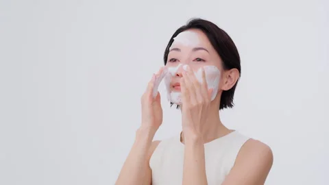 Skin care process. She is washing her face with foam on her face Video stock 343594239