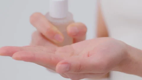 Skin care process. A woman's hand with a pump container, serum, and lotion .. Video stock 343592985