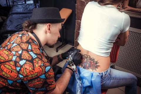 Skin master demonstrates process of making a tattoo Foto stock