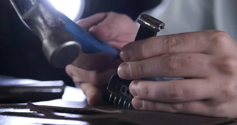 Skin Processing Wizard Prepares Leather for Edge Stitching. Strikes with Hammer Stock Footage 148128010
