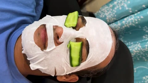 Skincare routine with hydrating face mask and cucumber slices for relaxation Stock Footage 333907925