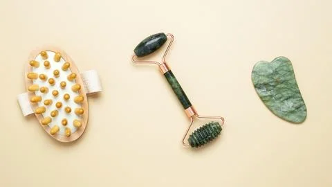 Skincare tools including marble roller, gua sha, and wooden brush arranged fo Stock-Fotos