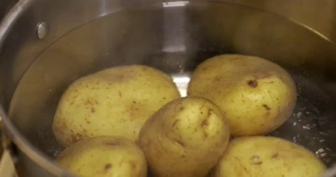 Skinned potatoes in a pot filled with boiling water Video stock 131188615
