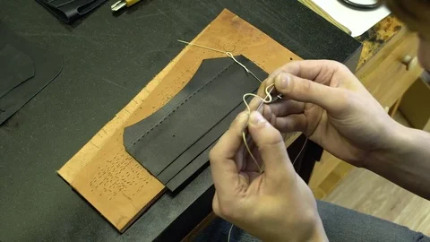 The skinner threads the thread into the needle on the background of the blank Stock Footage 77880019