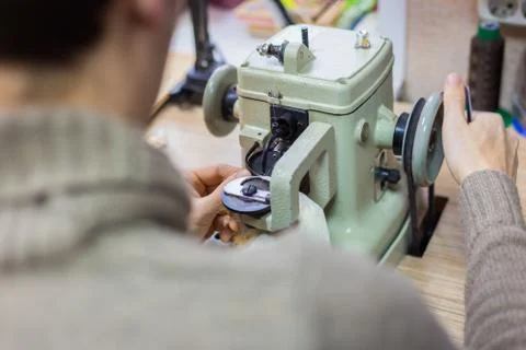 Skinner using sewing machine for stitching fur skin at atelier Stock Photos