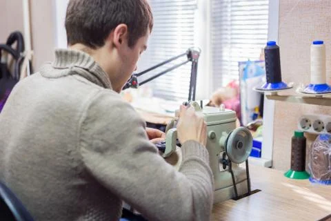 Skinner using sewing machine for stitching fur skin at atelier Stock Photos