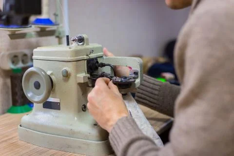 Skinner using sewing machine for stitching fur skin at atelier Stock Photos