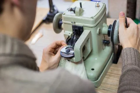 Skinner using sewing machine for stitching fur skin at atelier Stock Photos