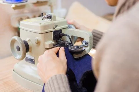 Skinner using sewing machine for stitching fur skin at atelier Stock Photos