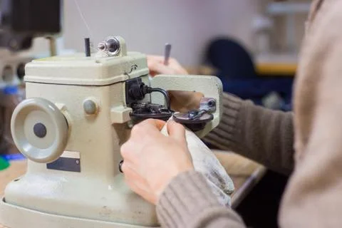 Skinner using sewing machine for stitching fur skin at atelier Stock Photos