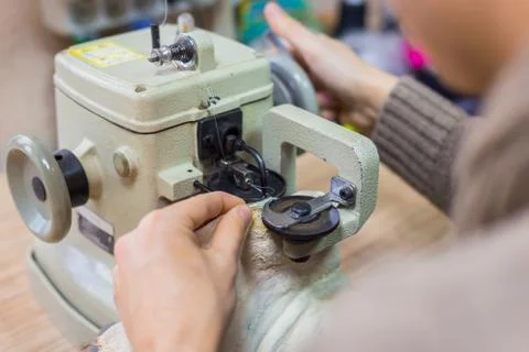 Skinner using sewing machine for stitching fur skin at atelier Stock Photos