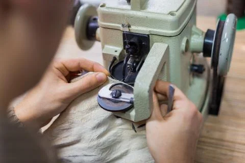 Skinner using sewing machine for stitching fur skin at atelier Stock Photos