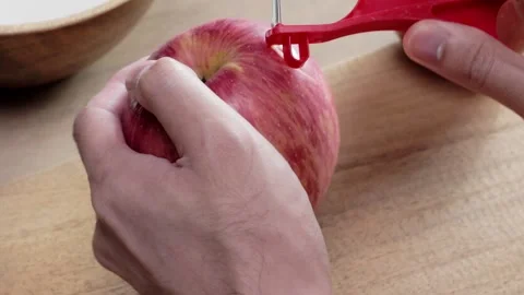 Skinning an apple using a kitchen peeler Stock Footage 165125185