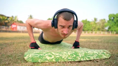 A skinny guy with a bare torso does push-ups off the floor. Video stock 231337164