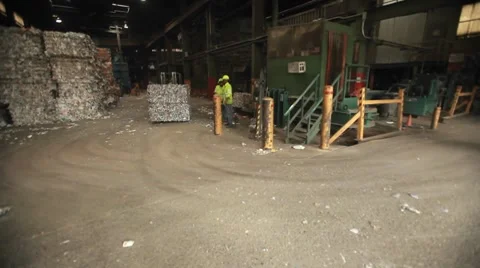 A skip loader moves aluminum cans at a recycling center. 库存影片 8524531