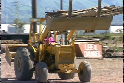SKIP LOADER MOVES WOOD Stock Footage 1049739