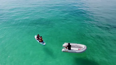 The skipper drags a SUP board behind him on an inflatable boat Stock Footage 169169355