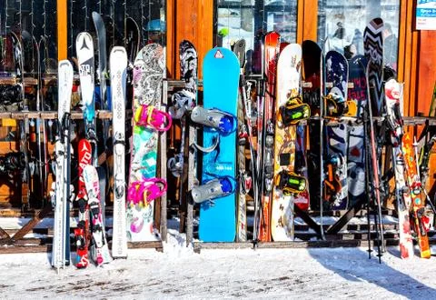 Skis and snowboards are standing on the racks Stock Photos