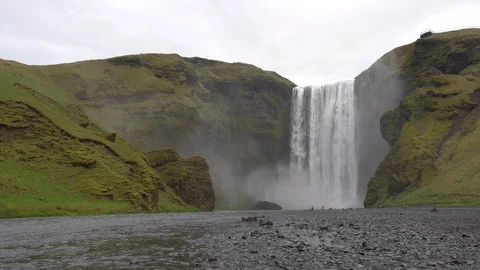 Skogafoss waterfall, with two tourists at the base Stock Footage 112306861