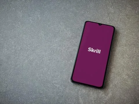 Skrill app launch screen on smartphone on ceramic stone background Stock Photos