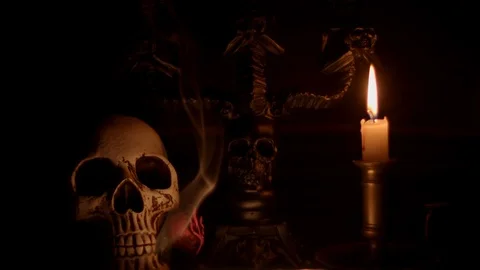 Skull and background lit by candle with smoke billowing Stock Footage 114230441