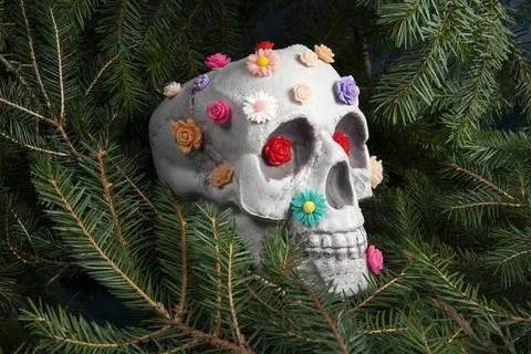 Skull covered with multiple plastic flowers in different colors Stock Photos