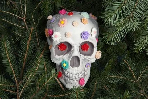 Skull covered with multiple plastic flowers in different colors Stock Photos