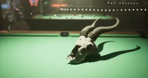 Skull with horns resting on a pool table in a lively game venue Stock Footage 321432599