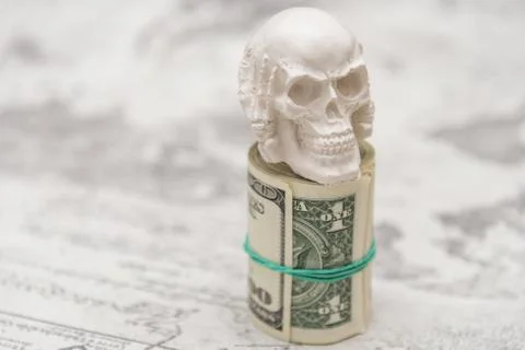 A skull standing on a bundle of money, twisted into a bundle Fotos Stock