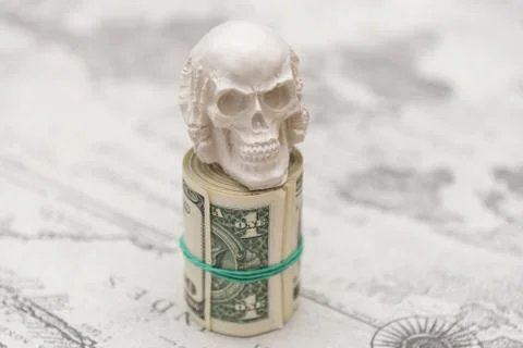 A skull standing on a bundle of money, twisted into a bundle Stock Photos